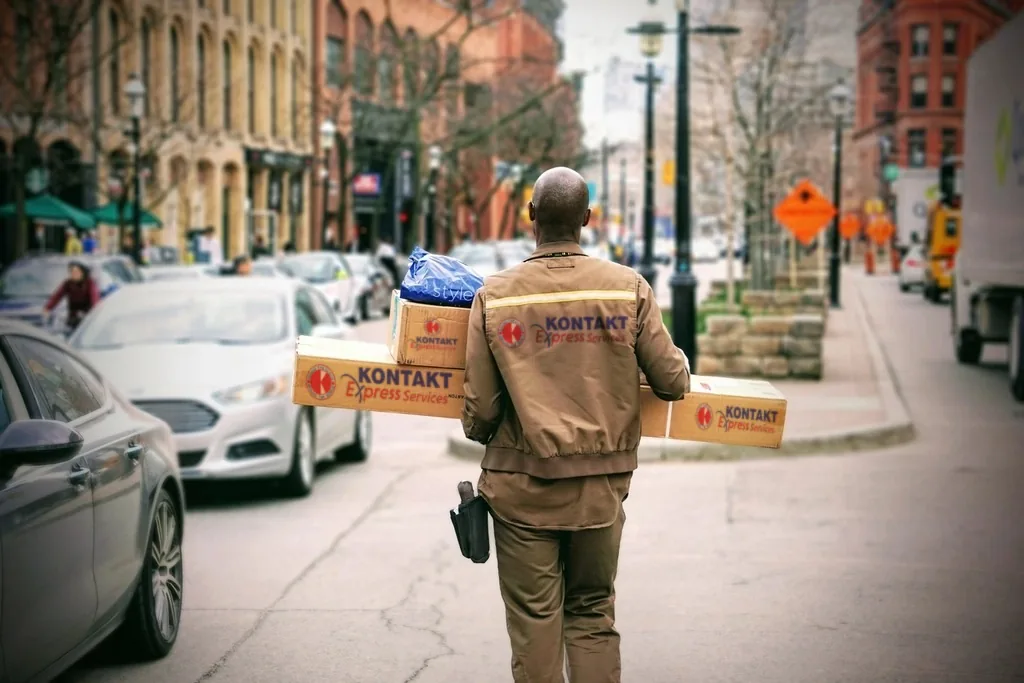 Courier in a Kontakt Express Services jacket carrying parcels