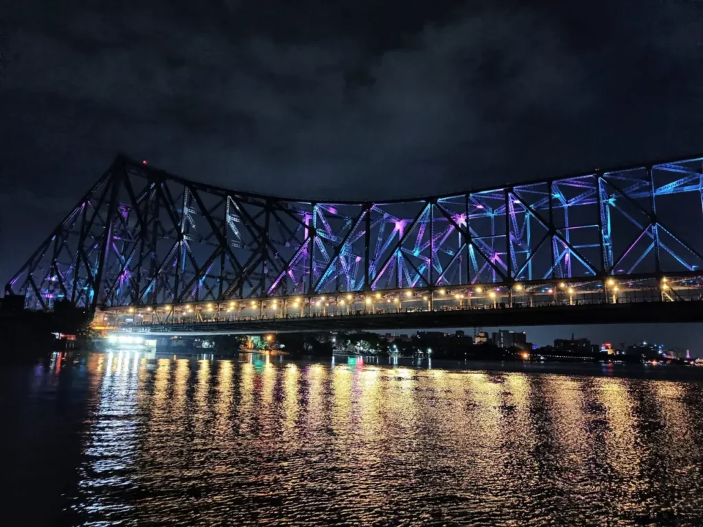 Howrah Bridge lit up at night over the Hooghly river, Kolkata